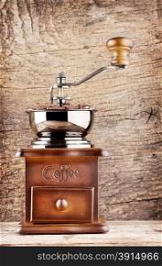 Coffee grinder with a handle on the wooden background