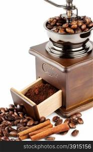 Coffee grinder with coffee beans and cinnamon isolated on white background