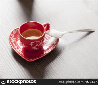 Coffee in a red cup, over wooden table, horizontal image