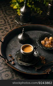 Coffee in metal Turkish traditional cup and coffee beans on dark tile background. Turkish Coffee in metal cup