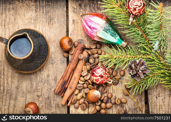 Coffee in retro cezve and christmas decoration on old wooden table. Christmas toy and coffe