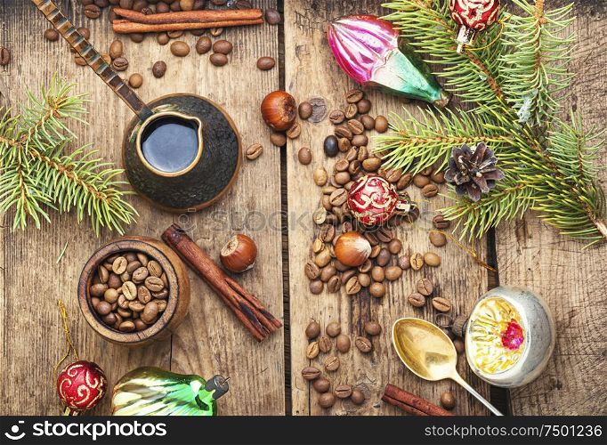 Coffee in retro cezve and christmas decoration on old wooden table. Christmas toy and coffe