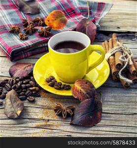 Coffee in the fall. Cup of black coffee on background with warm blanket strewn with autumn leaves