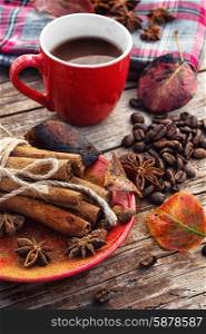Coffee in the fall. Cup of black coffee on background with warm blanket strewn with autumn leaves