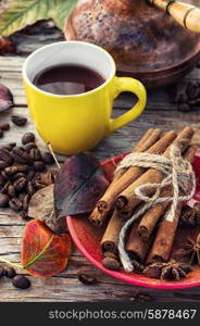 Coffee in the fall. Stylish porcelain Cup of coffee on background decorated with spices and strewn with autumn leaves