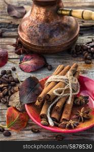Coffee in the fall. Stylish porcelain Cup of coffee on background decorated with spices and strewn with autumn leaves