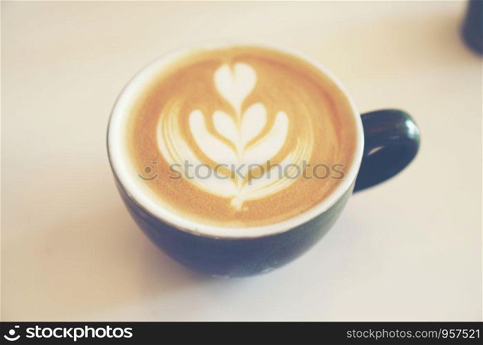coffee latte art in coffee cup, vintage filter image