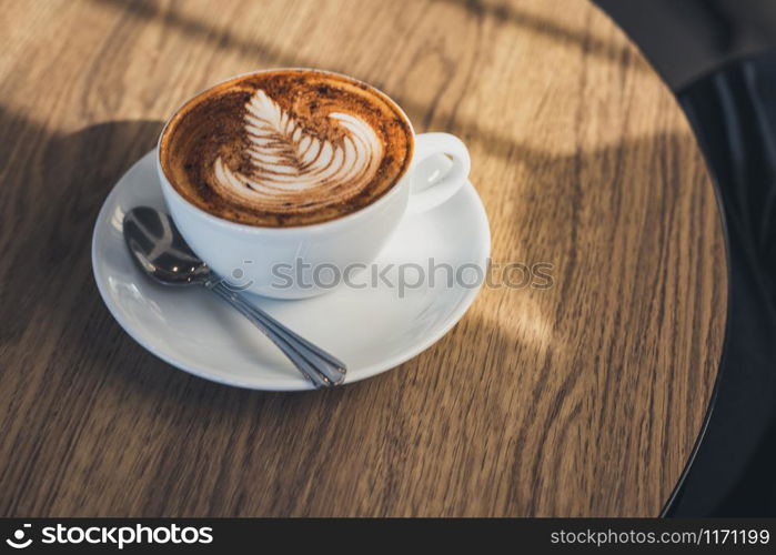 Coffee latte art on wooden table.