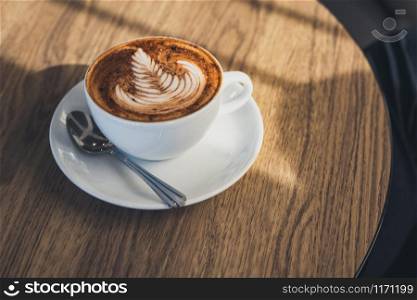 Coffee latte art on wooden table.