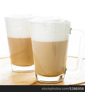 Coffee latte in glass mugs on the board
