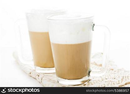 Coffee latte in glass mugs on white table