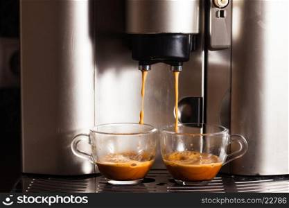 Coffee machine brewing a coffee espresso in home, two glass cups
