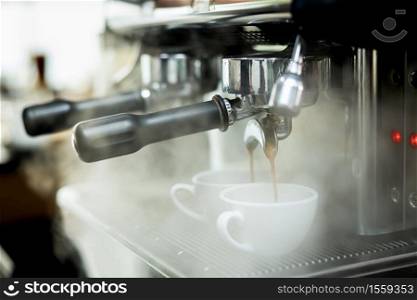 Coffee machine espressos shot and smoke in white cups