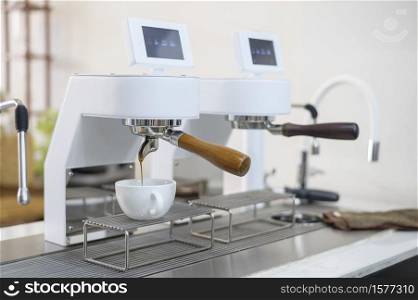 coffee machine making black coffee and pouring into a cup at cafe