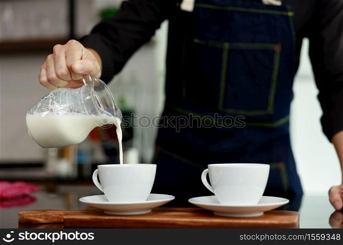 coffee maker pours milk mixed with hot coffee in coffee shop