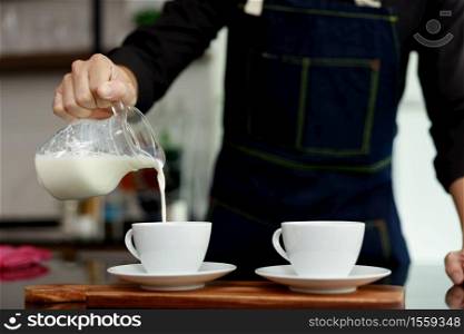 coffee maker pours milk mixed with hot coffee in coffee shop