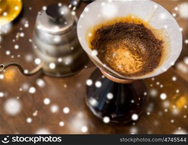 coffee making concept - close up of coffeemaker with filter and pot on table over snow. close up of coffeemaker and coffee pot