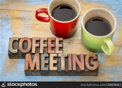 coffee meeting concept - text in vintage letterpress wood type printing blocks with two cups of coffee