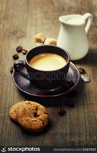 Coffee, milk and cookies on wooden background