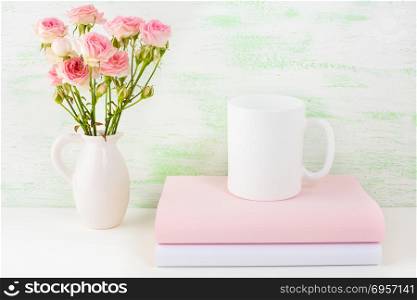 Coffee mug mockup with books and pink roses. Coffee cup mock-up for brand promotion. Empty mug mockup for design presentation.. Coffee mug mockup with books and pink roses