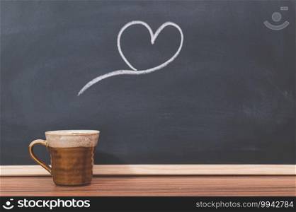 Coffee mugs and heart shapes on the blackboard