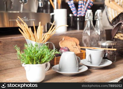 Coffee mugs and vases. Coffee in a coffee machine in the background.