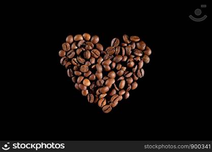 Coffee on a black background. Coffee beans in the form of heart. Coffee beans in the form of heart. Coffee on a black background. top view. macro