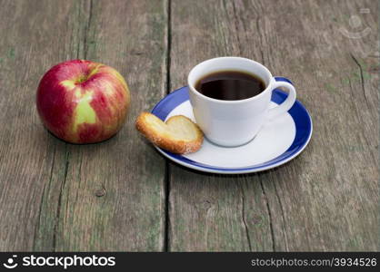 coffee on a saucer, cookies and one apple, on a wooden table, a subject food and drinks