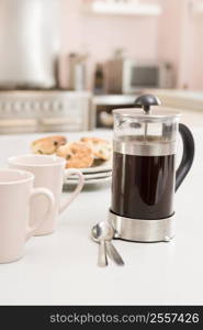 Coffee pot on kitchen counter with scones