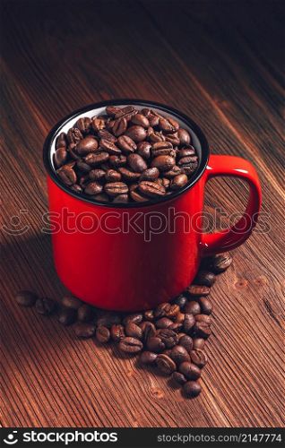 Coffee red mug with beans on wooden background. Coffee red mug with beans