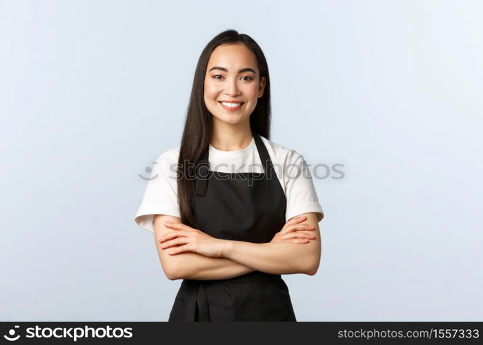 Coffee shop, small business and startup concept. Young cheerful asian girl barista wearing black apron, working in cafe, smiling standing bar counter, listening customer order.. Coffee shop, small business and startup concept. Young cheerful asian girl barista wearing black apron, working in cafe, smiling standing bar counter, listening customer order