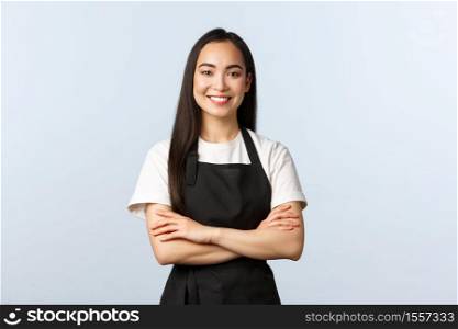 Coffee shop, small business and startup concept. Young cheerful asian girl barista wearing black apron, working in cafe, smiling standing bar counter, listening customer order.. Coffee shop, small business and startup concept. Young cheerful asian girl barista wearing black apron, working in cafe, smiling standing bar counter, listening customer order