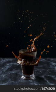 Coffee splash, A glass of cold coffee on a black background