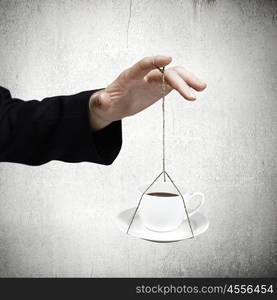 Coffee time. Close up of businessman hand holding cup on ropes