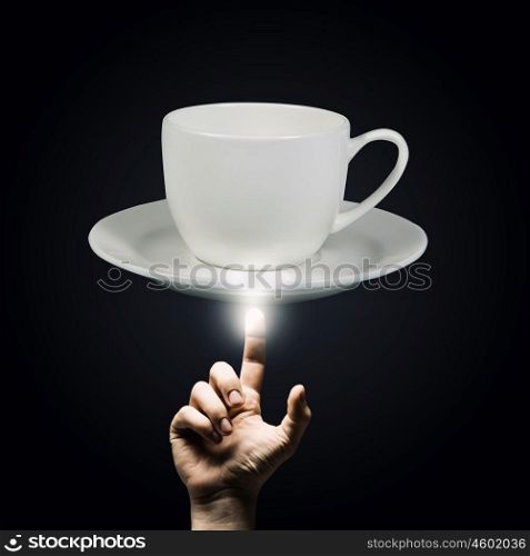 Coffee time. Human hand pointing with finger at cup of coffee