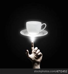 Coffee time. Human hand pointing with finger at cup of coffee