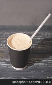 coffee to go in a paper cup with straw. coffee with milk froth, latte or cappuccino on wooden table. takeaway drinks in plastic free cup. coffee to go in a paper cup with straw. coffee with milk froth, latte or cappuccino on wooden table. takeaway drinks in plastic free cup.