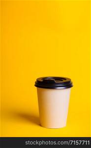 coffee to go. paper cup with coffee on a yellow background.