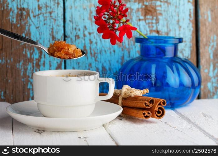 Coffee with caramel sugar and cinnamon on wooden table