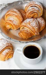 Coffee with fresh croissants on wooden table still life