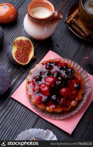coffee with natural cream, cake with berries and tasty ripe purple fig on black wooden table. flat lay. life style concept