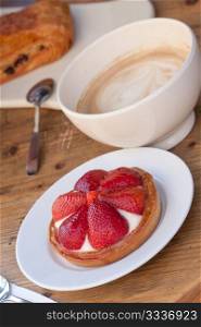 Coffee with strawberry cake in wooden table