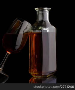 Cognac bottle and glass isolated on black