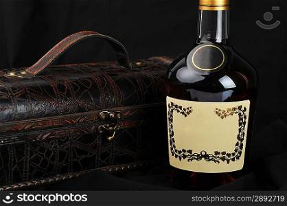 Cognac bottle near to leather case background