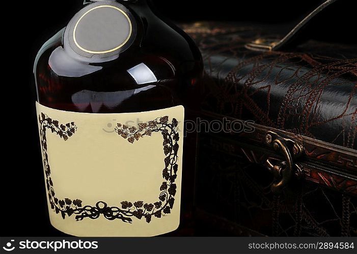 Cognac bottle near to leather case background