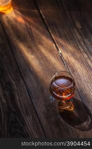 Cognac in glass on the wooden surface. Cognac in glass on the wood