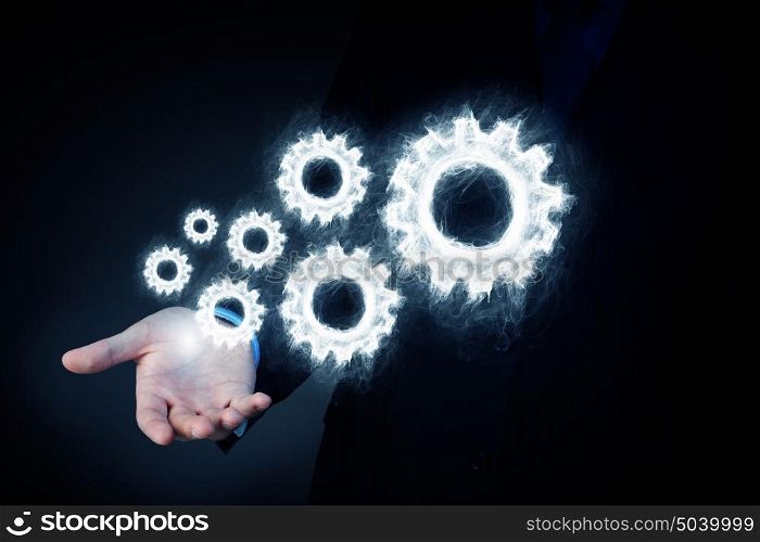 Cogwheel mechanism as teamwork concept. Business person hand holding gear mechanism representing interaction concept