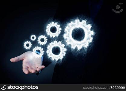 Cogwheel mechanism as teamwork concept. Business person hand holding gear mechanism representing interaction concept