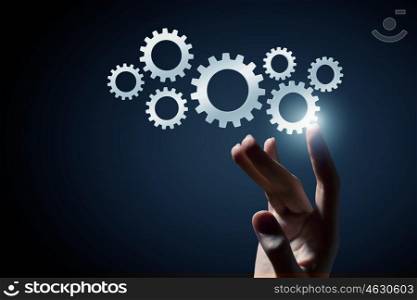Cogwheel mechanism as teamwork concept. Business person hand touching gear mechanism representing interaction concept