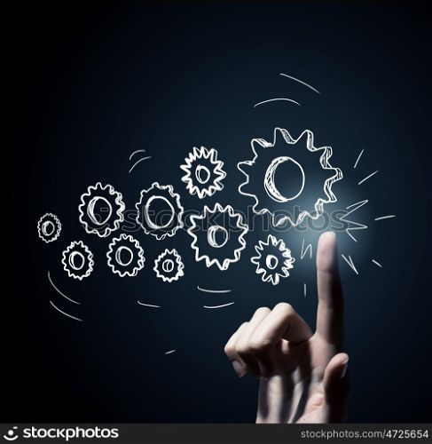 Cogwheel mechanism as teamwork concept. Business person hand touching gear mechanism representing interaction concept